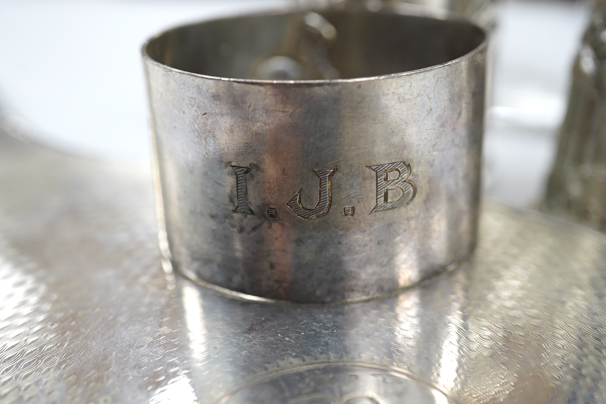 Small silver including a napkin ring, hand mirror and two mounted glass toilet jars, together with three Indian white metal condiments and a French white metal wine taster. Condition - poor to fair